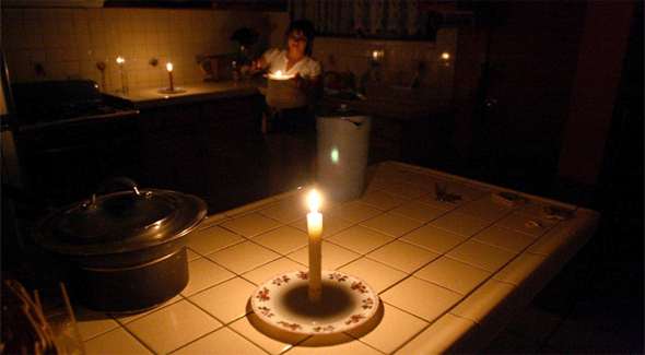 Woman preparing dinner in her kitchen in the dark